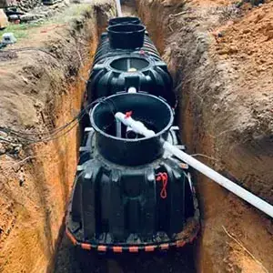 Plastic septic tank set in a trench with three risers and a PVC inlet pipe Plastic septic tank set in a trench with three risers and a PVC inlet pipe